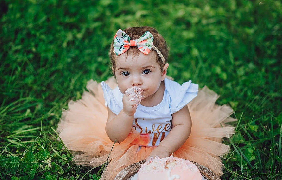 Fallon is registered to the contest to win money with this photo: baby, baby_toddler_clothing, child, dress, eye, face, facial_expression, flash_photography, grass, happy, headband, headgear, headpiece, headwear, mammal, people_in_nature, person, plant, skin, summer
