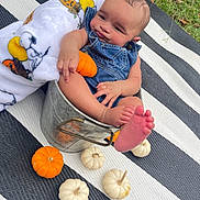 Tommy James joined the competition — help win amazing prizes! autumn, baby, blanket, bucket, child, cute, denim_overalls, fall, festive, foot, grass, hand, holiday, infant, mini_pumpkin, outdoor, person, pumpkin, relaxed, striped_mat