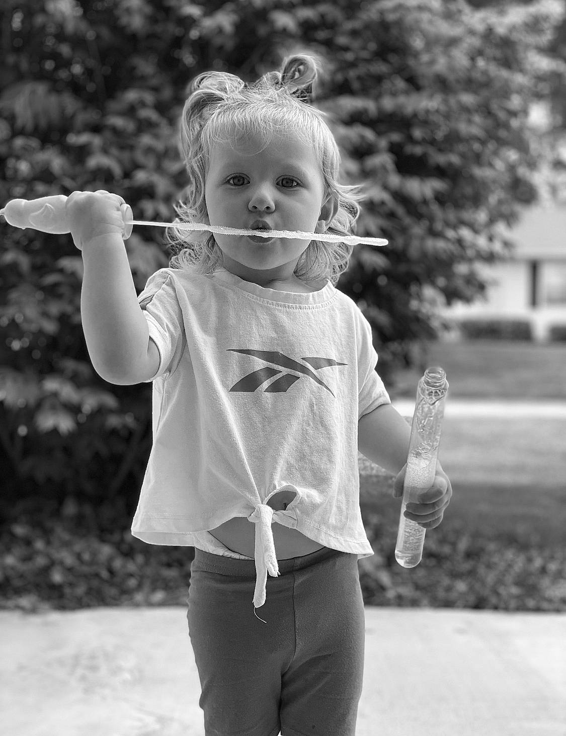 Ava is registered to the contest to win money with this photo: arm, black, black_and_white, cool, eyewear, flash_photography, gesture, grass, hand, happy, human_body, joint, people_in_nature, person, shoulder, sleeve, standing, style, t_shirt, toddler