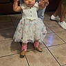 Amari joined the competition — help win amazing prizes! adult, baby, boots, child, cowboy_boots, cute, dress, family, floor, hands, holding_hands, home, indoor, person, pink_boots, standing, support, tile_floor, toddler, white_dress