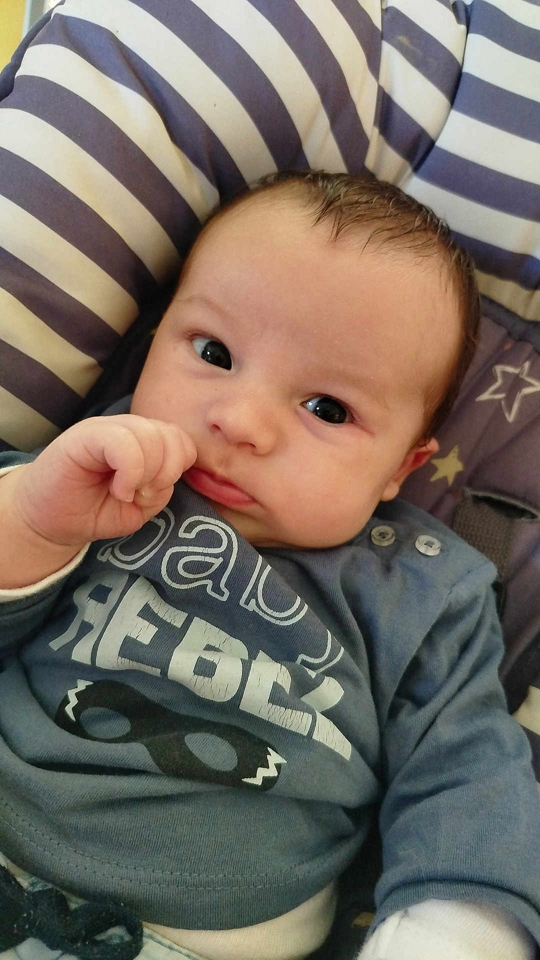 Augustin participe au concours pour gagner de l'argent avec cette photo : baby, infant, child, face, eyes, hand, thumb, clothing, shirt, text, cushion, striped, pattern, seated, portrait, indoors, cute, young, closeup, person