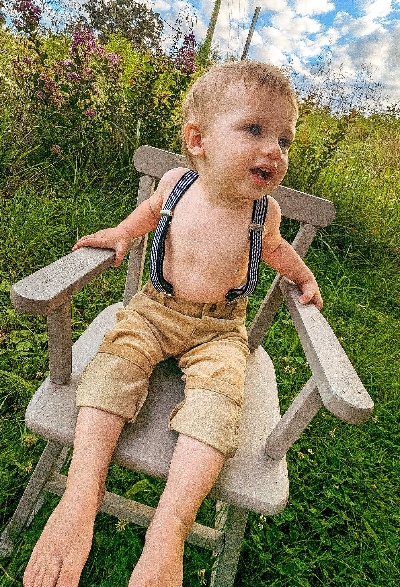 Killian is registered to the contest to win money with this photo: baby_toddler_clothing, barefoot, chair, cloud, finger, fun, grass, happy, human_body, leg, leisure, people_in_nature, person, plant, shorts, skin, sky, smile, standing, thigh