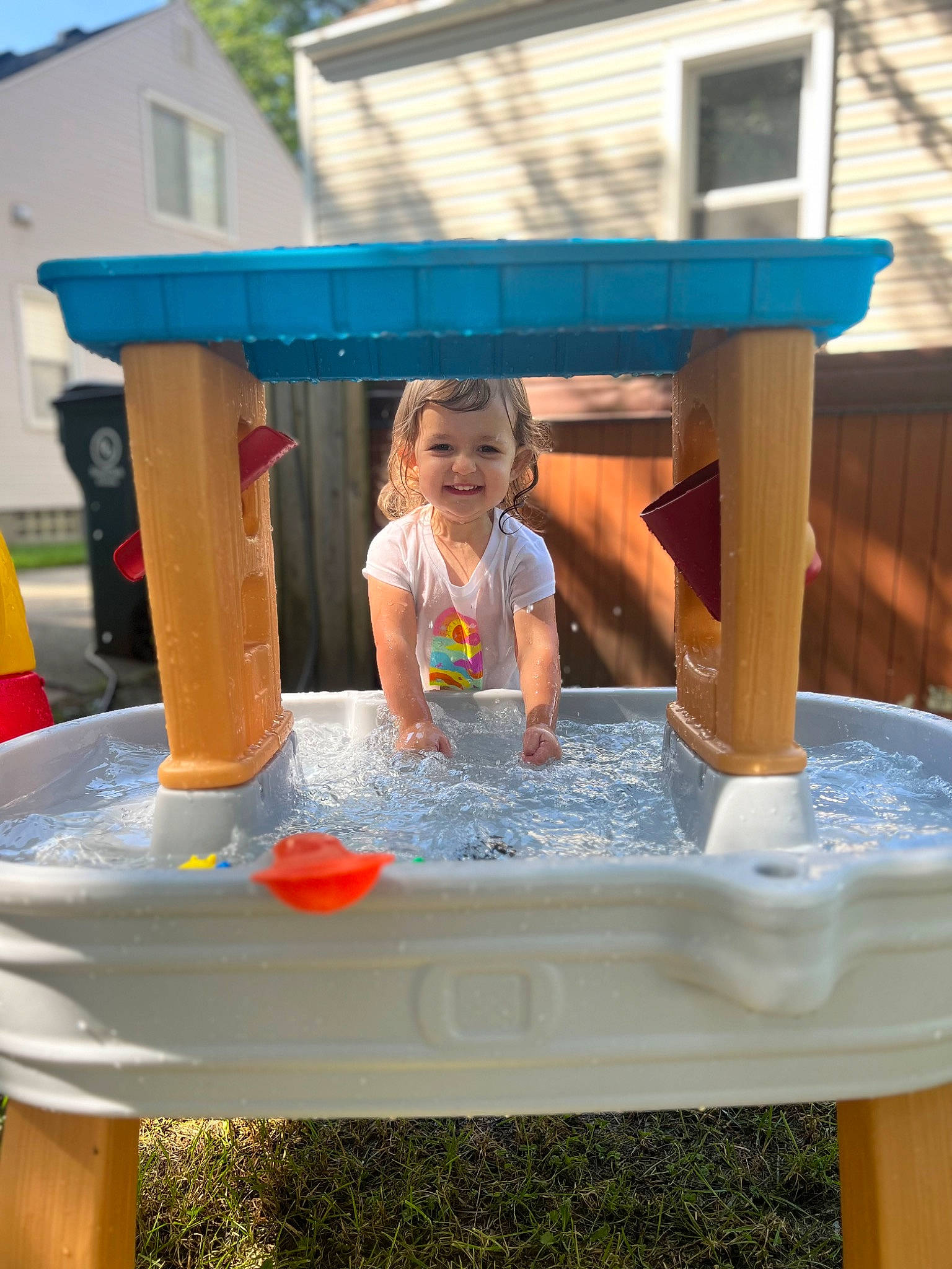 Emmy joined the competition — help win amazing prizes! blue, building, dress, fun, grass, happy, joy, leisure, outdoor_furniture, outdoor_play_equipment, person, public_space, recreation, shorts, smile, summer, t_shirt, table, toddler, water