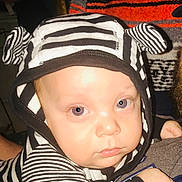 Johnny Cash is registered to the contest to win money with this photo: baby, child, hoodie, striped_clothing, face, eyes, cute, infant, portrait, close_up, expression, baby_clothes, black_and_white, ears, person, young_child, indoor, looking_at_camera, skin, headwear