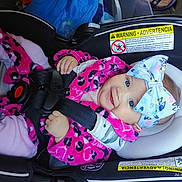 Bella is registered to the contest to win money with this photo: baby, child, car_seat, safety_harness, pink_clothing, headband, bow, smile, blue_eyes, infant, seatbelt, cute, happy, indoors, portrait, clothing, toddler, child_safety, car, seat