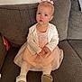 cardigan, casual, child, couch, cute, dress, furniture, girl, home, indoor, looking_up, pink_bows, portrait, sitting, soft_lighting, stockings, thoughtful, toddler, white_shoes, young_child
