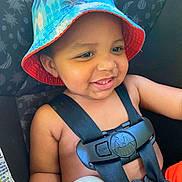 Hunter joined the competition — help win amazing prizes! baby, child, toddler, smiling, happy, portrait, bucket_hat, car_seat, safety_harness, vehicle, indoor, seated, face, eyes, teeth, infant, travel, colorful, close_up, photography