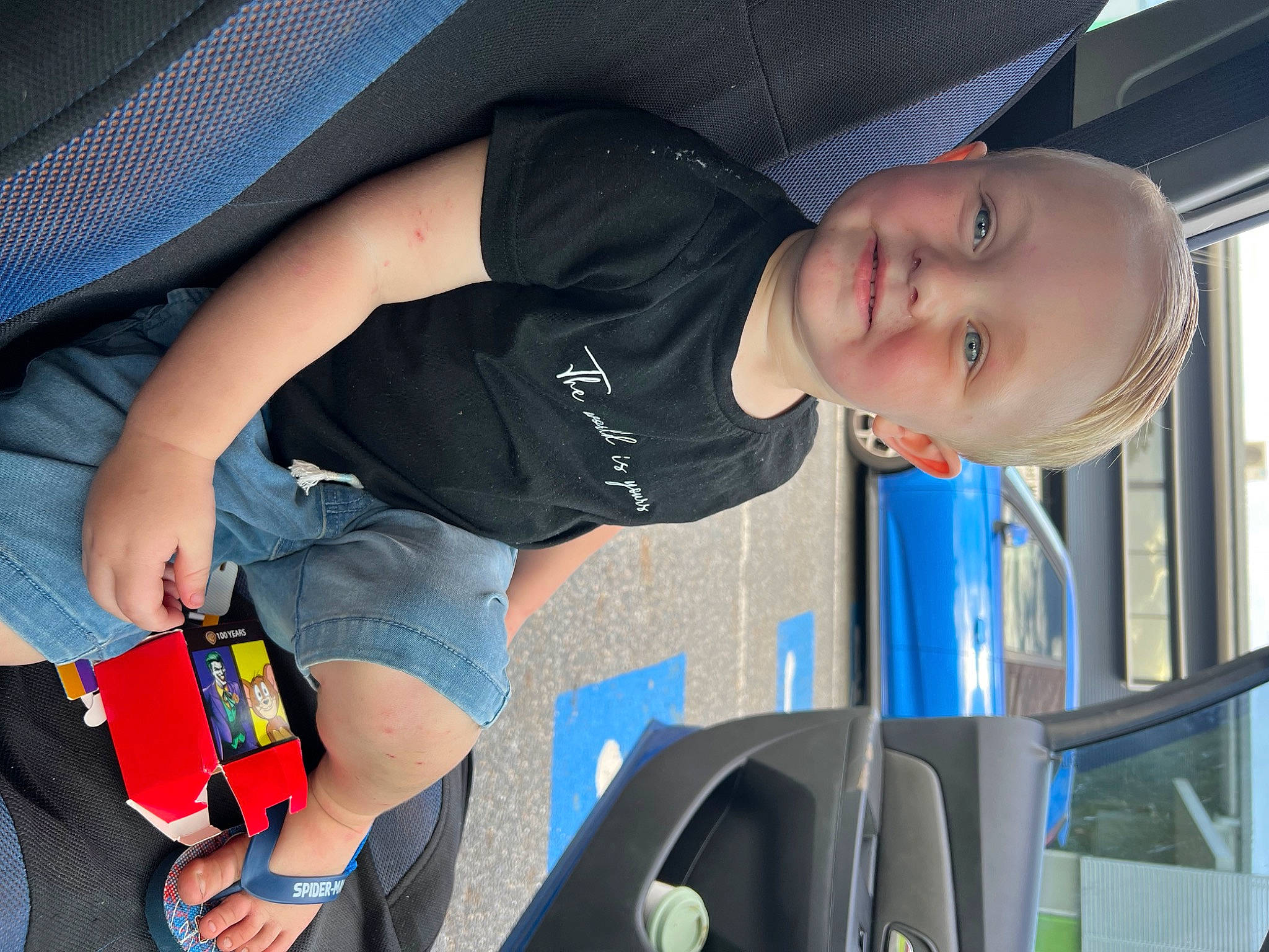 Parker is registered to the contest to win money with this photo: auto_part, automotive_design, automotive_exterior, bumper, child, elbow, electric_blue, fun, human_leg, joint, joy, knee, lap, motor_vehicle, mouth, person, shorts, smile, t_shirt, thigh