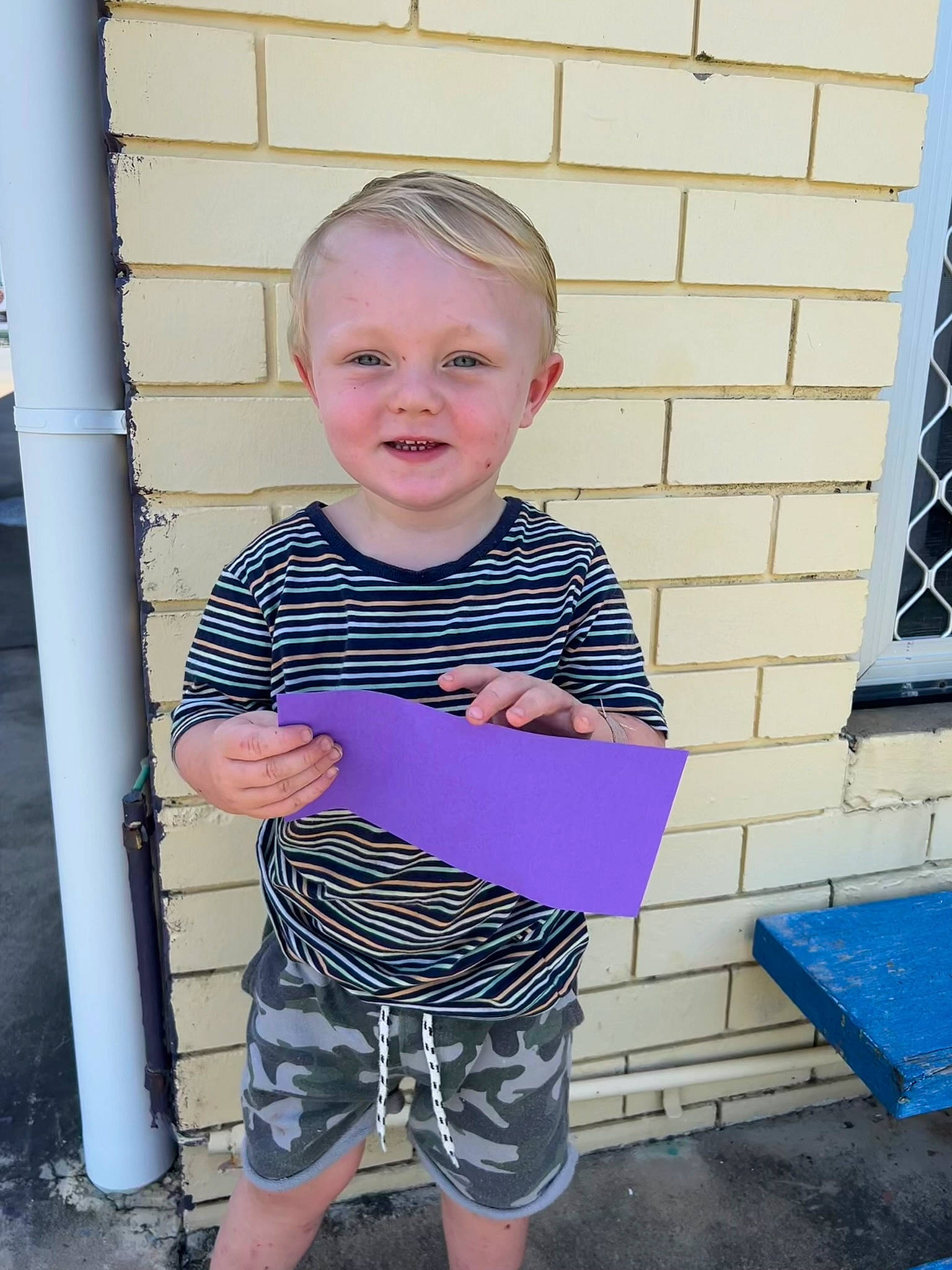 Parker is registered to the contest to win money with this photo: baby_toddler_clothing, bermuda_shorts, blue, child, denim, electric_blue, face, facial_expression, fun, happy, magenta, pattern, person, shorts, shoulder, sleeve, smile, standing, t_shirt, toddler