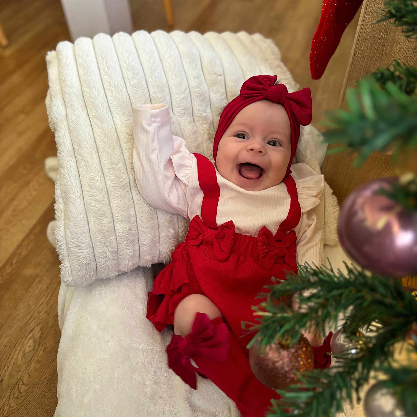 Soëlya participe au concours pour gagner de l'argent avec cette photo : baby, blanket, celebration, christmas_tree, cushion, cute, decor, festive, happy, headband, holiday, home, indoor, infant, ornaments, person, red_clothing, smiling, toddler, wood_floor