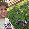 Zeus is registered to the contest to win money with this photo: man, dog, grass, outdoor, smile, cap, tshirt, fence, tree, pet, canine, harness, leisure, sunlight, portrait, nature, happy, casual, yard, daytime