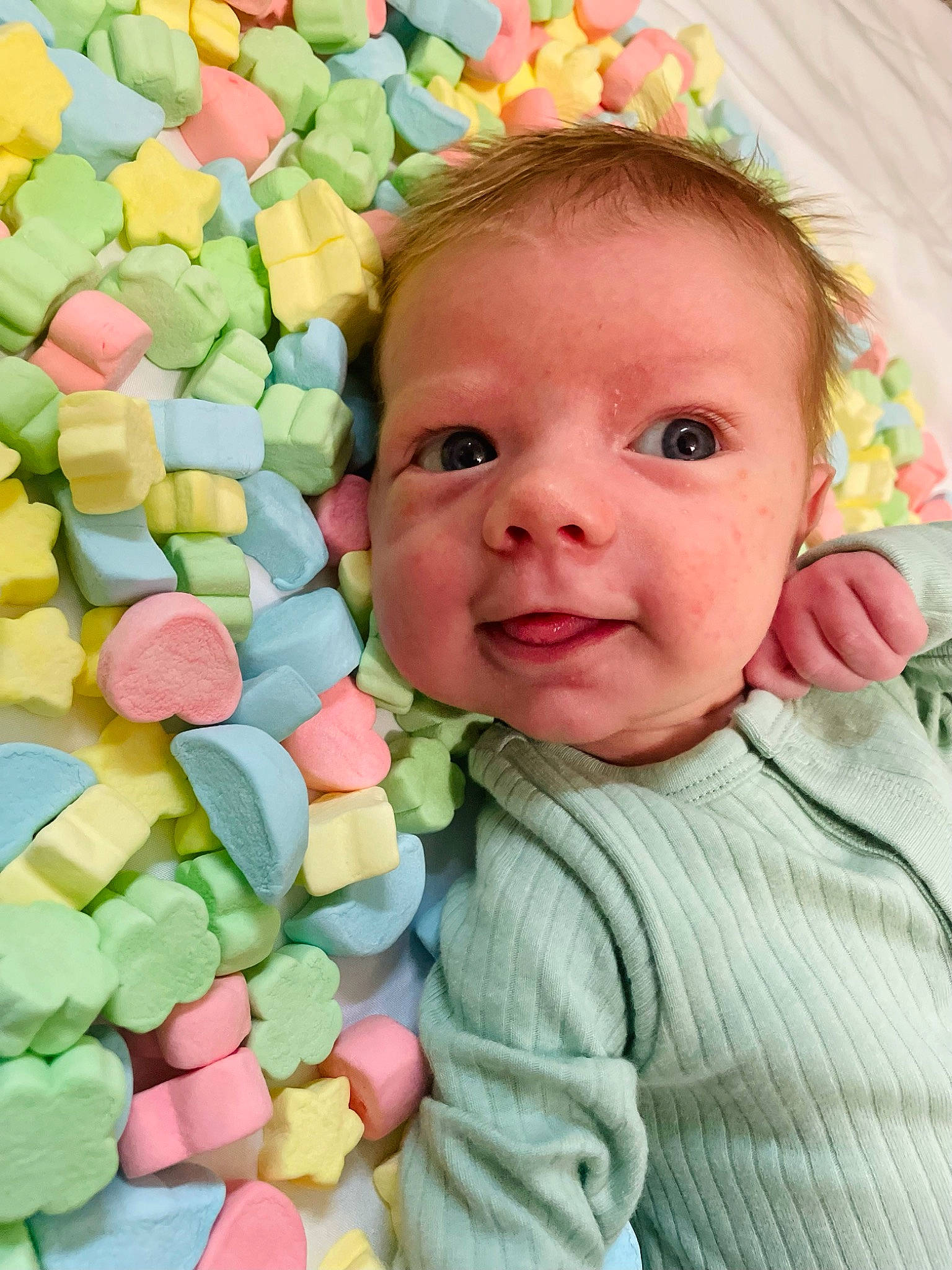 Hudson is registered to the contest to win money with this photo: baby, baby_products, baby_toddler_clothing, cheek, child, event, eye, face, facial_expression, fun, happy, iris, linens, pattern, people_in_nature, person, petal, play, sleeve, smile