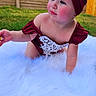 Jade is registered to the contest to win money with this photo: baby, bodypart, bonnet, cap, clothing, costume, dress, face, finger, formalwear, glove, grass, hand, hat, head, person, photography, plant, portrait, wood