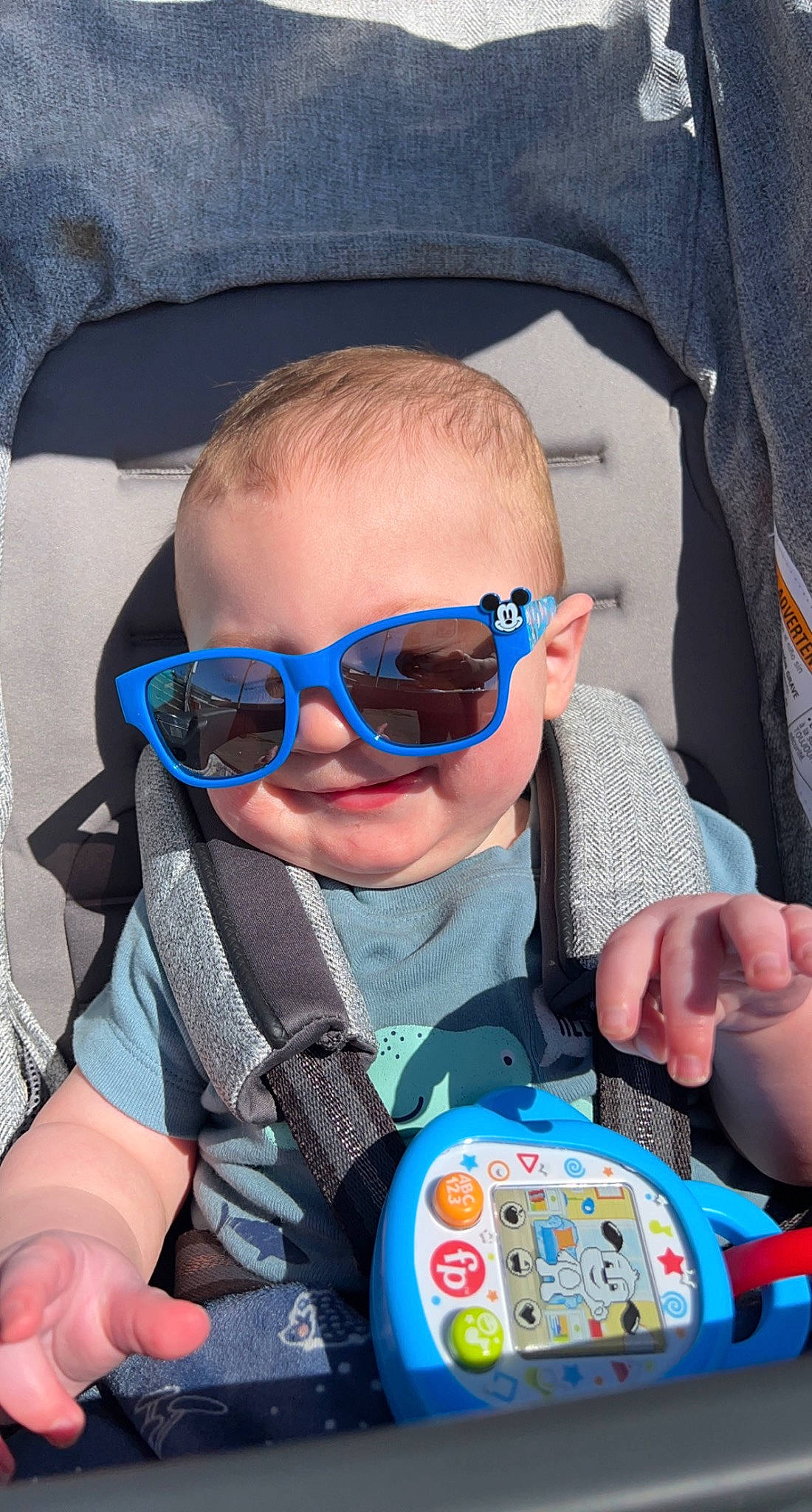 Colt is registered to the contest to win money with this photo: azure, baby_toddler_clothing, car_seat, child, comfort, cool, electric_blue, eyewear, finger, fun, goggles, mouth, person, personal_protective_equipment, product, sleeve, smile, sunglasses, toddler, vision_care