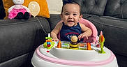 Leonna joined the competition — help win amazing prizes! baby, walker, smile, indoor, couch, pillow, toy, doll, child, happy, living_room, carpet, footwear, person, hair_bow, milestone, furniture, pink, gray, playtime