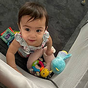 Leonna joined the competition — help win amazing prizes! toddler, child, baby, toys, plush_toy, playpen, carpet, indoor, curious, looking_up, colorful, soft, mesh, clothing, person, cute, young_child, infant, smiling, holding