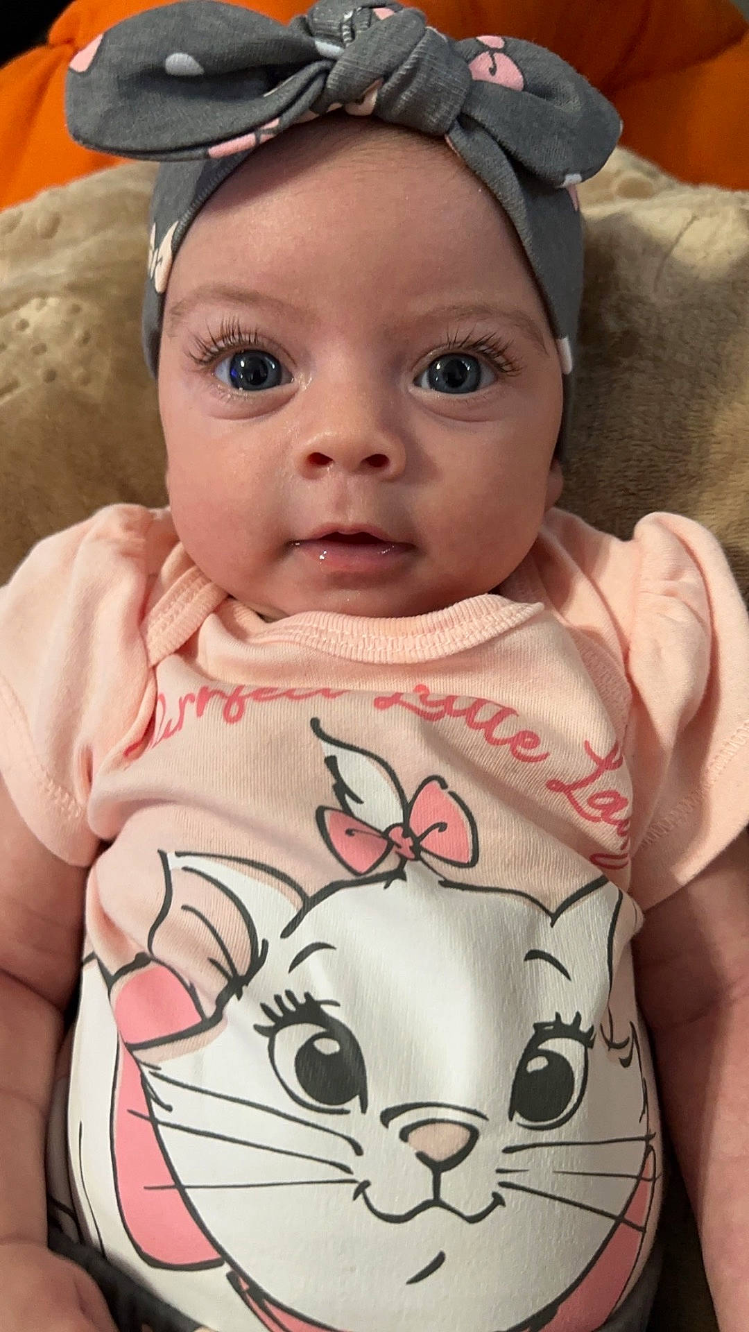 Violet is registered to the contest to win money with this photo: accessories, baby, baseballcap, cap, clothing, couch, cushion, face, furniture, happy, hat, head, headband, homedecor, newborn, person, photography, portrait, sitting, t_shirt