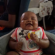 Avaylah is registered to the contest to win money with this photo: baby, baby_bottle_holder, bib, blanket, chair, child, clothing, cute, hanging_clothes, happy, headphones, home, indoor, infant, mickey_mouse, person, portrait, seated, smiling, socks