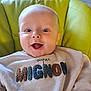 Nolan participe au concours pour gagner de l'argent avec cette photo : baby, smiling, child, face, sweater, clothing, indoor, seat, chair, happy, cute, portrait, young, infant, human, person, light, expression, comfort, cozy