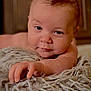 baby, infant, child, face, eyes, hand, fingers, blanket, shaggy_blanket, tuft_of_hair, mohawk, skin, portrait, close_up, cozy, indoor, expression, lying_down, soft_texture, warm_lighting