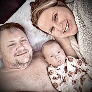 Creed joined the competition — help win amazing prizes! baby, man, woman, family, bed, pajamas, cookie_pattern, smile, lying_down, closeup, face, skin, hair, fleece, comfort, indoor, relaxation, portrait, people, happy