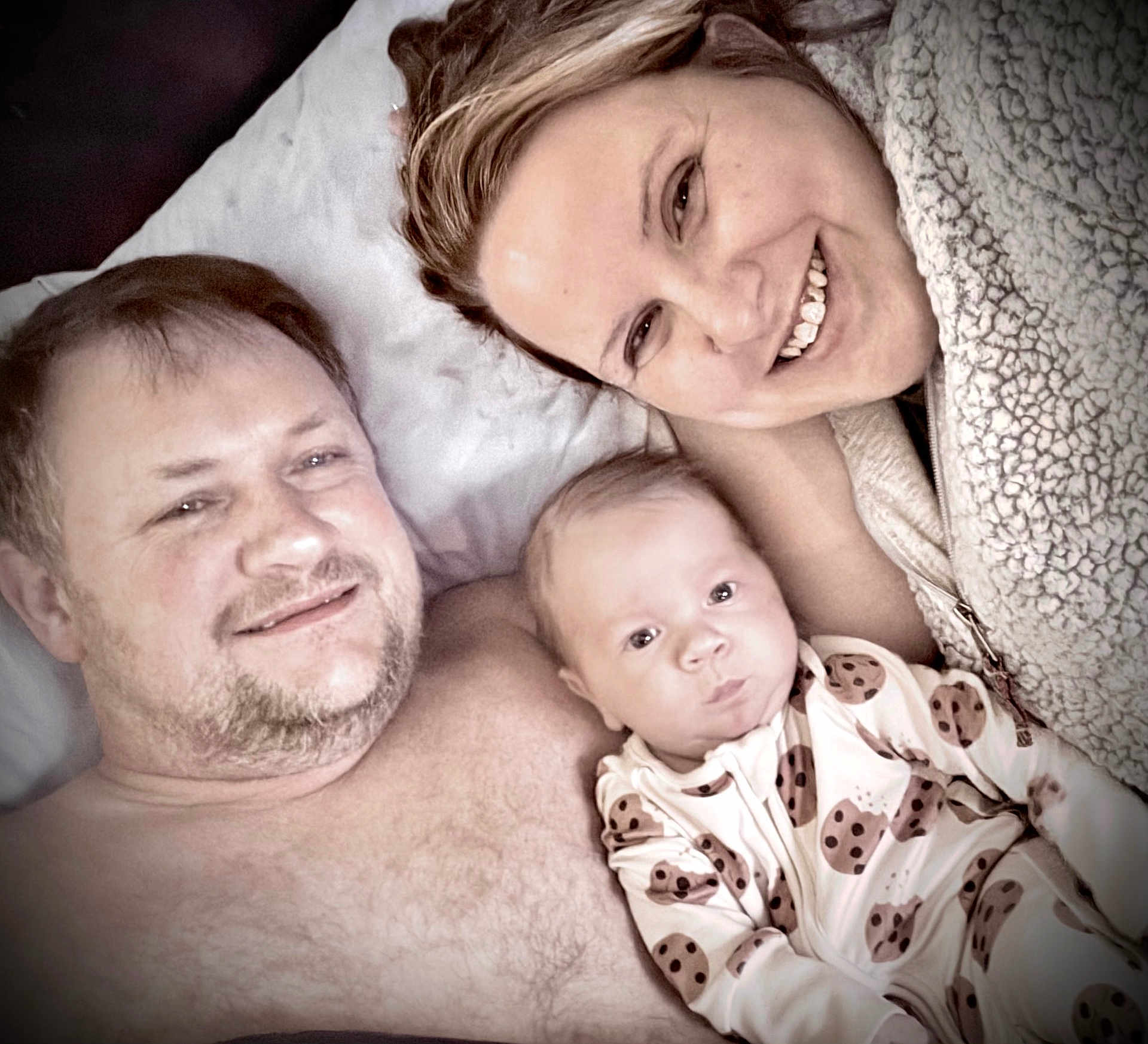 Creed joined the competition — help win amazing prizes! baby, man, woman, family, bed, pajamas, cookie_pattern, smile, lying_down, closeup, face, skin, hair, fleece, comfort, indoor, relaxation, portrait, people, happy