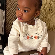 Chloe joined the competition — help win amazing prizes! toddler, child, baby, indoors, couch, sneakers, white_shoes, cute_outfit, long_sleeves, plush_texture, earrings, curly_hair, seated, cozy, cushions, soft_lighting, portrait, expression, curious, home