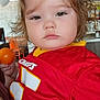 Ember joined the competition — help win amazing prizes! child, toddler, curly_hair, red_jersey, sports_jersey, indoor, balloon, orange_ball, face, portrait, expression, holding, person, clothing, furniture, chair, background, skin, eyes, hair