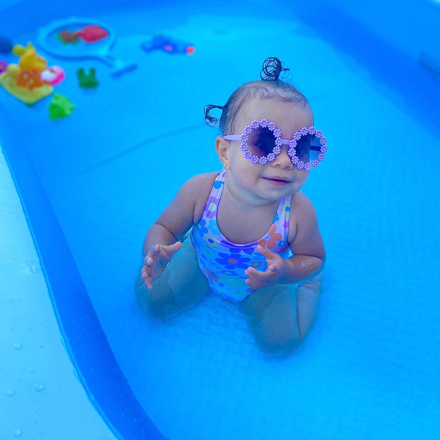 Ariah participe au concours pour gagner de l'argent avec cette photo : blue, child, cute, fun, hair_buns, happy, outdoor, plastic_pool, playful, pool, sitting, small_pool, summer, sunglasses, sunshine, swimsuit, toddler, toys, water, water_toys