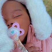 Malya a rejoint le concours — aidez-le/la à gagner de superbes lots ! baby, sleeping, pacifier, pink_jacket, fluffy_hood, hand, red_nail_polish, close_up, outdoor, green_background, peaceful, child, infant, cozy, cute, portrait, warm_clothing, toddler, face, soft
