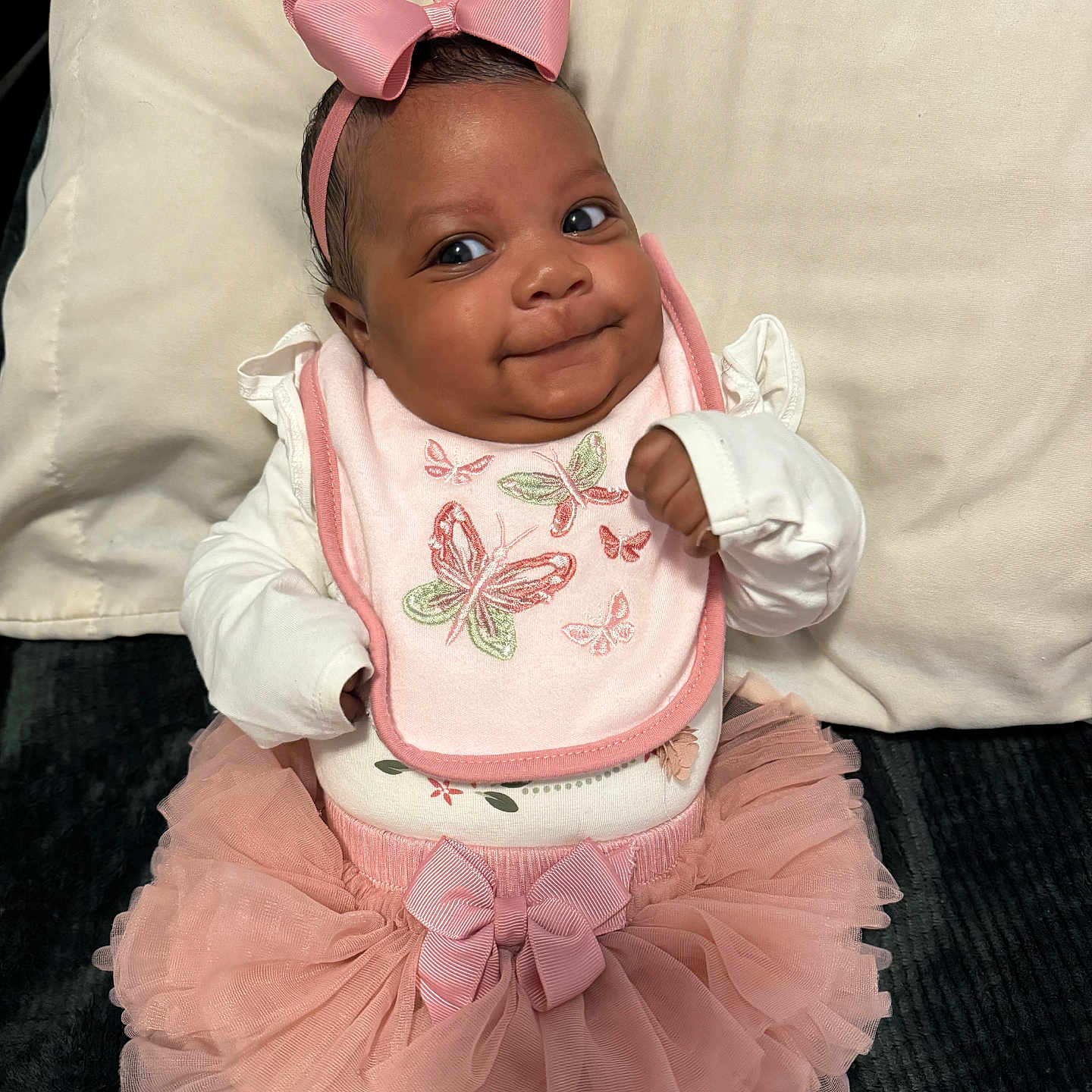 Cai is registered to the contest to win money with this photo: accessories, baby, bodypart, bonnet, clothing, costume, couch, dress, face, finger, furniture, hand, happy, hat, head, person, photography, portrait, sitting, smile