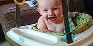 Jaxson joined the competition — help win amazing prizes! baby, smiling, baby_jumper, indoor, living_room, furniture, couch, carpet, toy, child, happy, seat, person, home, playtime, infant, strap, plastic, green, blue