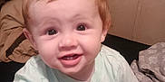 Jaxson is registered to the contest to win money with this photo: baby, child, smile, face, red_hair, toy, bed, blanket, clothing, infant, cute, person, indoors, happy, young_child, sitting, playful, skin, hand, foot