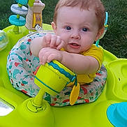 Jaxson joined the competition — help win amazing prizes! baby, child, toy, activity_center, yellow, green, blue, outdoor, grass, play, infant, seat, cute, person, face, hands, expression, young, summer, fun