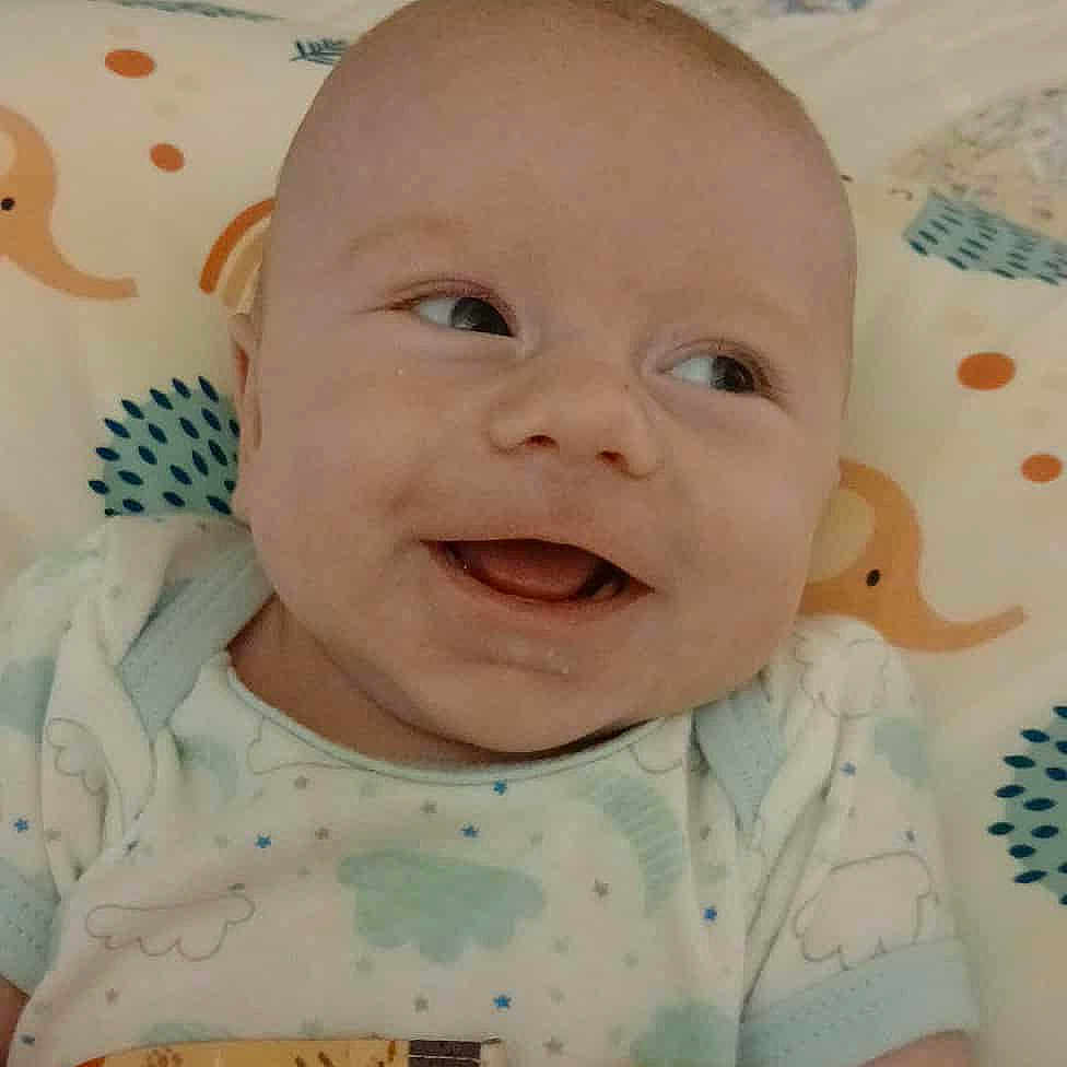 Sawyer joined the competition — help win amazing prizes! baby, bed, child, clothing, comfort, cute, expression, face, happy, indoor, infant, lying_down, pacifier, patterned, person, pillow, skin, smiling, soft, young