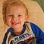 Kobe is registered to the contest to win money with this photo: child, toddler, smile, face, blond_hair, pajamas, blanket, pillow, indoor, happy, cute, portrait, young_child, bedroom, cozy, person, clothing, resting, lying_down, closeup