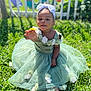 toddler, child, flower, green_dress, grass, outdoor, sunlight, headband, white_bow, nature, garden, fence, happy, cute, smiling, sitting, summer, portrait, baby, playful