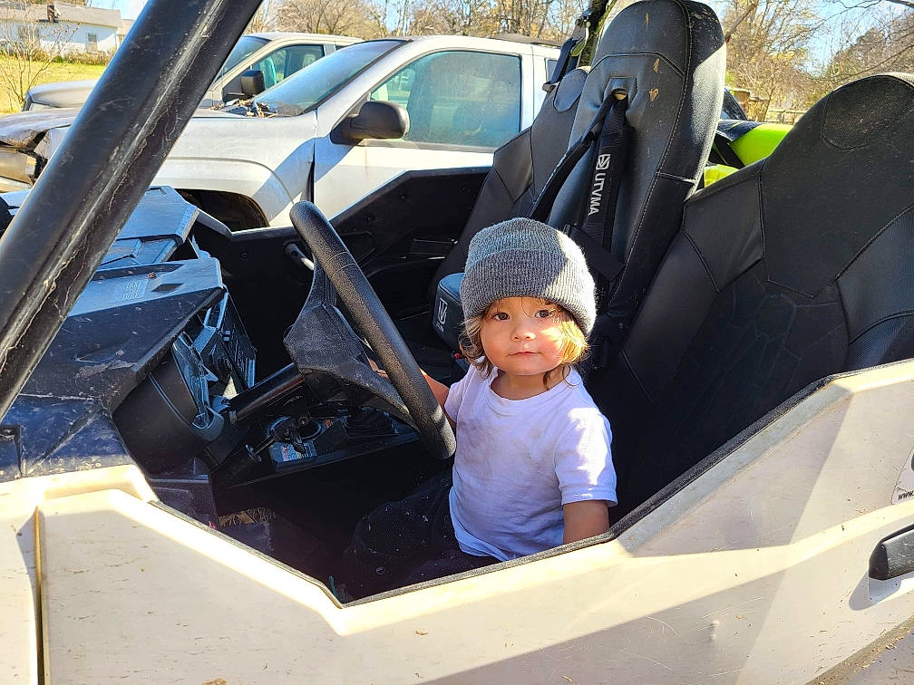 Gunnar is registered to the contest to win money with this photo: auto_part, automotive_design, automotive_exterior, automotive_tire, automotive_wheel_system, bumper, car, car_seat_cover, fender, hat, headwear, hood, mode_of_transport, motor_vehicle, person, personal_luxury_car, tire, toddler, vehicle, vehicle_door