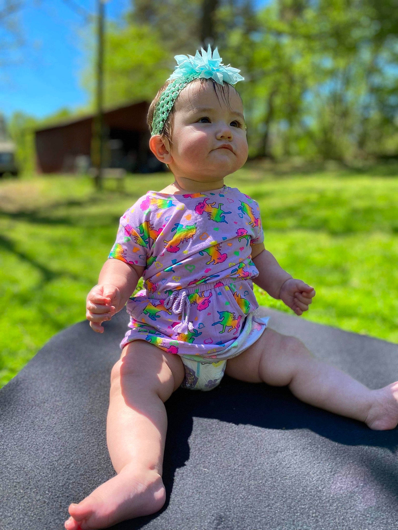 Georgia is registered to the contest to win money with this photo: baby, baby_toddler_clothing, barefoot, child, dress, foot, fun, grass, happy, headwear, human_leg, leaf, pattern, person, pink, plant, recreation, sitting, sky, sleeve