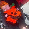 baby, infant, sleeping, stroller, pumpkin_costume, orange, beanie, halloween, costume, buckle, harness, outdoor, park, path, portrait, face, child, covered, travel, cute