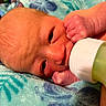 Amelia joined the competition — help win amazing prizes! newborn, baby, infant, face, eyes, bottle, feeding, milk, blanket, swaddled, lying_down, sleepy, hand, fingers, portrait, close_up, indoors, colorful, cozy, parenting