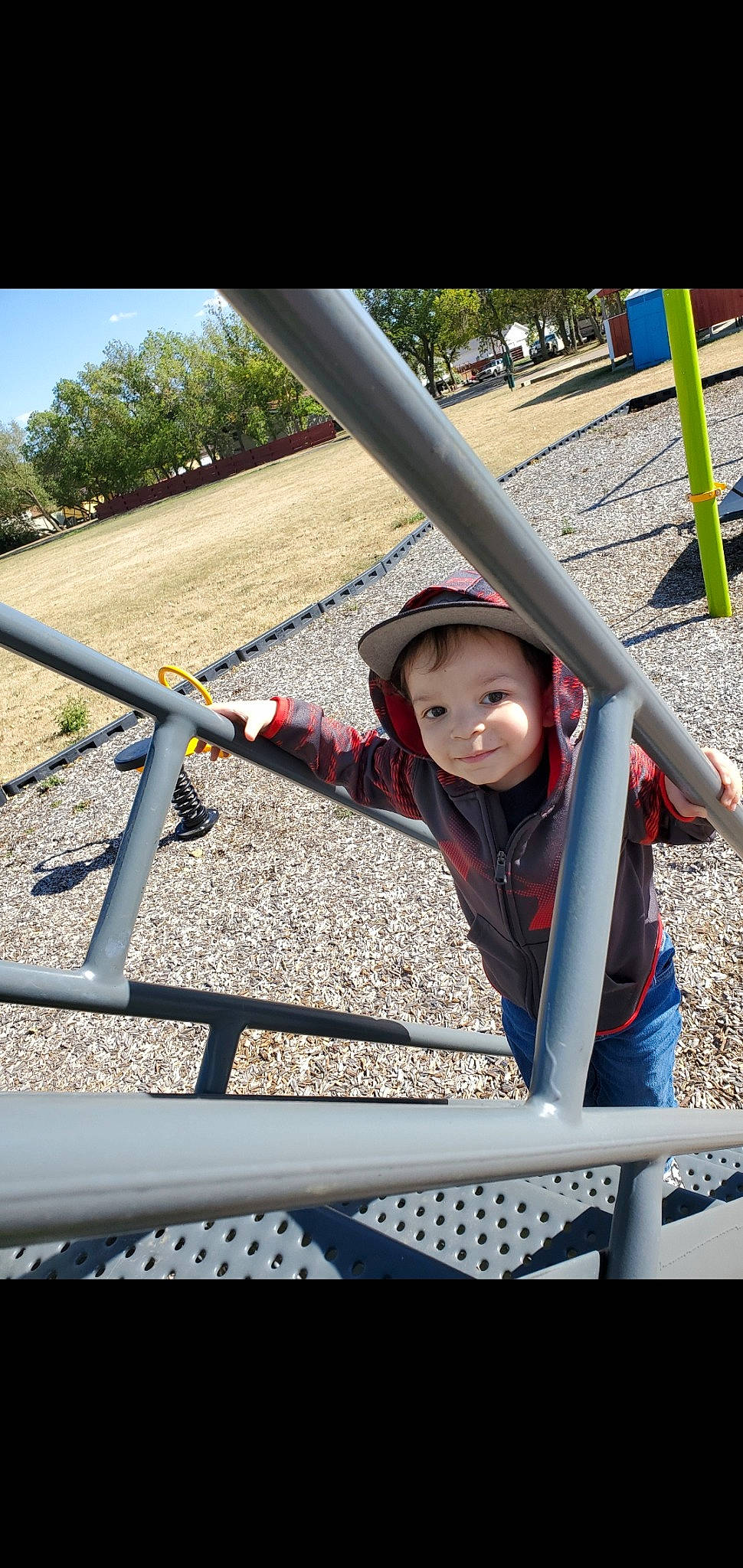 Gatlin is registered to the contest to win money with this photo: baby, baby_toddler_clothing, eye, human_settlement, joy, mouth, outdoor_play_equipment, person, play, playground, public_space, shade, toddler