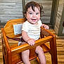 baby, high_chair, smile, wooden_furniture, indoor, child, happy, infant, person, flooring, wood, face, sitting, cute, short_sleeves, clothing, bright, eyes, hair, hand