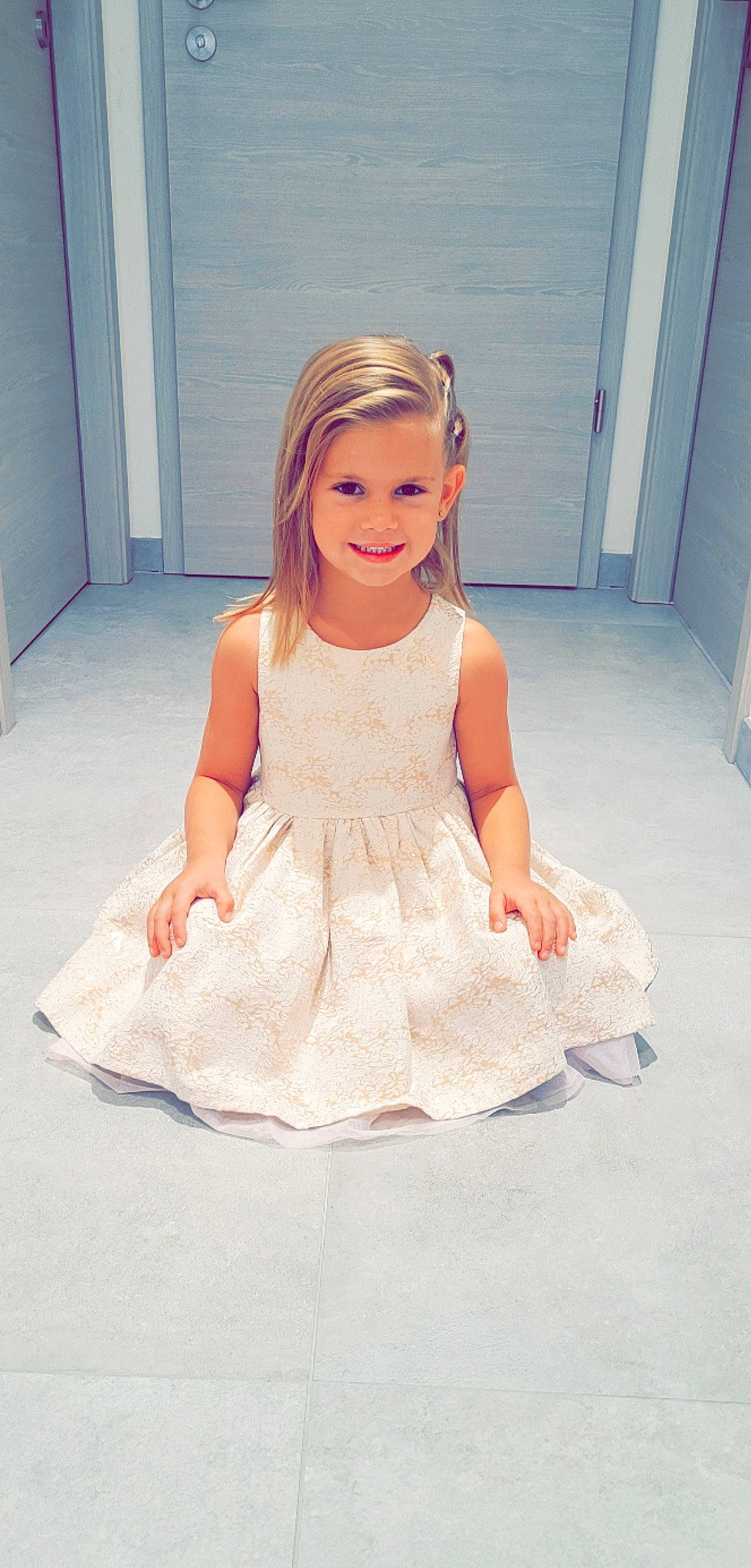 Elya participe au concours pour gagner de l'argent avec cette photo : baby_toddler_clothing, bridal_clothing, bridal_party_dress, day_dress, door, dress, embellishment, fashion_design, formal_wear, gown, happy, human_body, joy, leg, neck, one_piece_garment, person, ruffle, sleeve, smile
