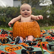 Ezra joined the competition — help win amazing prizes! baby, pumpkin, blanket, outdoor, grass, smiling, child, fall, halloween, cute, nature, holiday, seasonal, person, fun, sitting, orange, green, face, sock