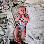 Cayden joined the competition — help win amazing prizes! baby, infant, newborn, child, blanket, couch, pillow, onesie, sports_pattern, soccer_ball, basketball, fabric, cozy, hands, feet, face, lying_down, portrait, home_interior, toddler
