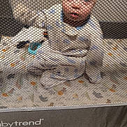 Atlas is registered to the contest to win money with this photo: baby, blanket, blue, carpet, child, clothing, crib, curious, face, furniture, home, indoor, infant, mesh, nursery, playpen, portrait, sitting, toys, white