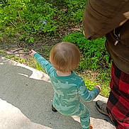 Liam joined the competition — help win amazing prizes! toddler, child, outdoor, nature, greenery, sidewalk, stick, pajamas, dinosaur_pattern, footwear, adult, pants, checkered, walking, exploring, sunlight, shadow, person, casual_clothing, daytime