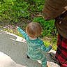 toddler, child, outdoor, nature, greenery, sidewalk, stick, pajamas, dinosaur_pattern, footwear, adult, pants, checkered, walking, exploring, sunlight, shadow, person, casual_clothing, daytime