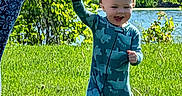 Liam joined the competition — help win amazing prizes! toddler, child, dinosaur_onesie, grass, adult_hand, tattoo, outdoor, sunny, greenery, pond, smiling, walking, nature, happy, person, daylight, holding_hand, baby, footwear, casual_wear